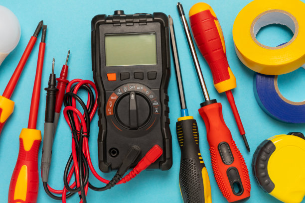 电工设备在蓝色背景与复制空间。前视图。电工工具集。万用表，测试仪，螺丝刀，刀具，胶带，灯具，卷尺和电线。些。图片下载