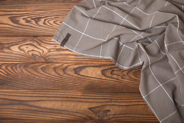 新的朴素图案的厨房毛巾折叠在灰色纹理的桌子上。厨房用具。厨房毛巾或餐巾纸。文本的复制空间。放文字的地方。桌布。图片下载