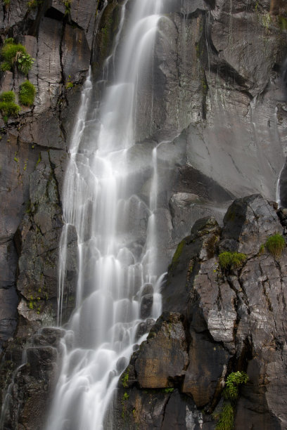 小瀑布从悬崖上倾泻而下的特写图片下载