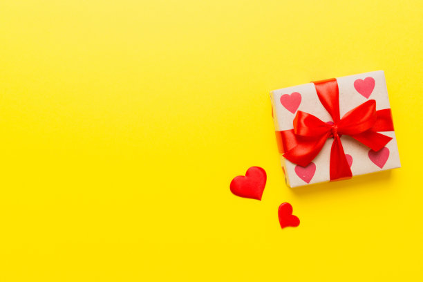 情人节装饰礼盒与红丝带蝴蝶结彩色背景的俯视图照片。假日礼盒与顶视图图片下载