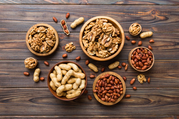 把核桃仁切成两半，放在木碗里。特写，从上面的彩色背景。健康吃核桃理念。有复制空间的超级食物图片下载