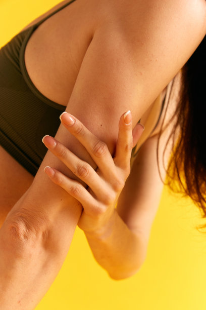 女性身体的剪裁图像，手在黄色工作室背景下。修指甲。护理。美容、spa图片下载