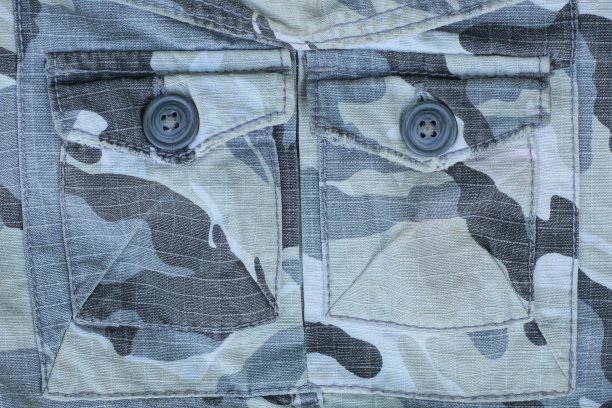 在斑点织物的口袋上有两个黑色塑料纽扣图片下载