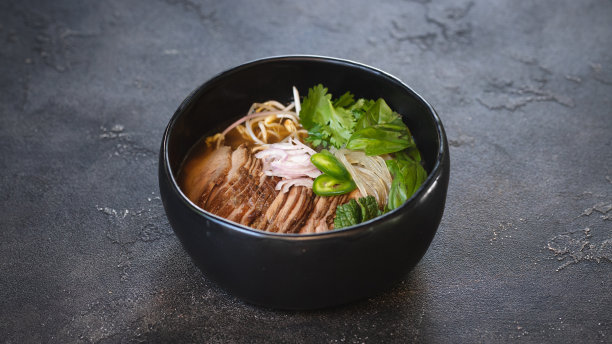 亚洲食品。开胃汤，肉和面条在黑暗的背景。图片下载