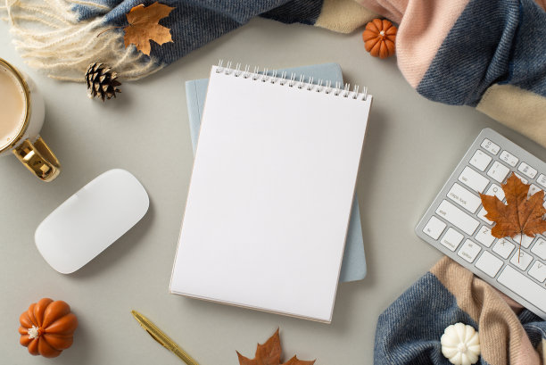 体验舒适的自由职业者的工作在秋天与这顶视图图片设有记事本镀金笔，键盘，热可可杯与舒适围巾灰色孤立的背景与copyspace图片下载