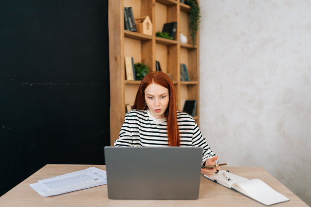 积极的女性自由职业者的肖像，右手受伤，用白色石膏绷带包裹着，正在进行在线视频通话，在笔记本电脑上远程工作图片下载