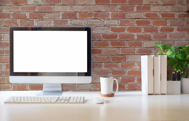 舒适的工作空间的正面视图，电脑，书籍和文具在桌子上。图片下载