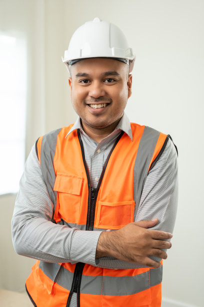 自信的工程师帅哥垂直于现代家居建筑施工。工地上戴白色安全帽的建筑师。在建的房地产建筑。工头高级工龄图片下载