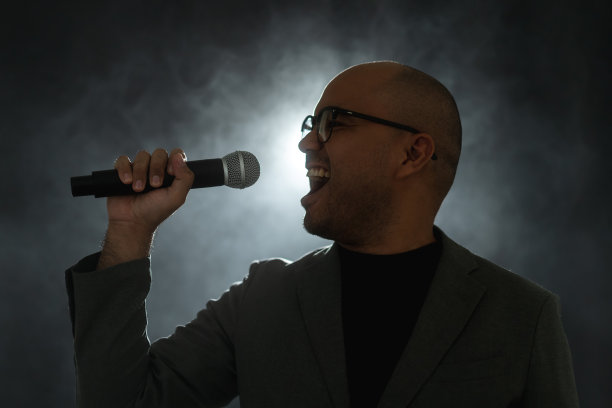 在公司商业活动中，自信成功的演说家在舞台上讲话，聚光灯照亮了黑暗。在会议大厅演讲的公众演说家。喜剧演员。图片下载