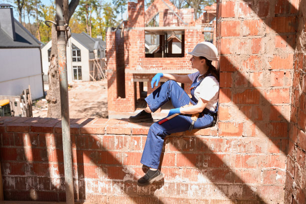 女建筑工程师休息，坐在房子的窗洞里图片下载