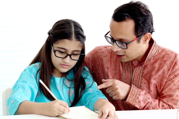 可爱的印度女学生穿着传统服装，戴着眼镜和父亲一起做作业，父亲在家教女儿孩子，父母成为家庭教师，参与儿童教育图片下载