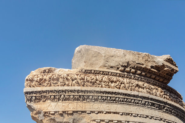 古老的安塔利亚古代纪念碑的上部，上面有花卉装饰和碑文碎片(用希腊语献给罗马诸神)。土耳其安塔利亚图片下载