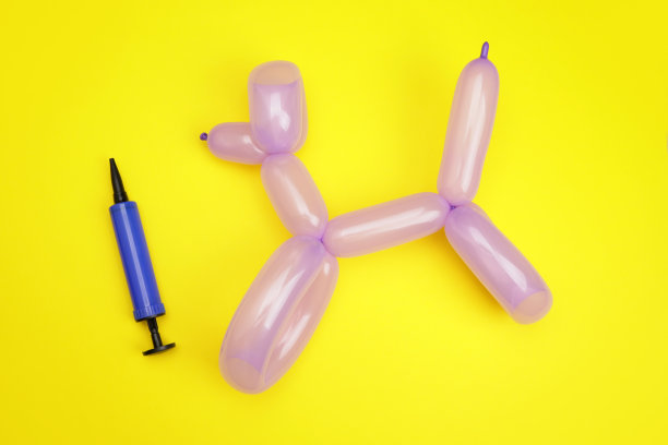 玩具狗来自一个黄色背景的气球，是孩子们庆祝的概念图片下载