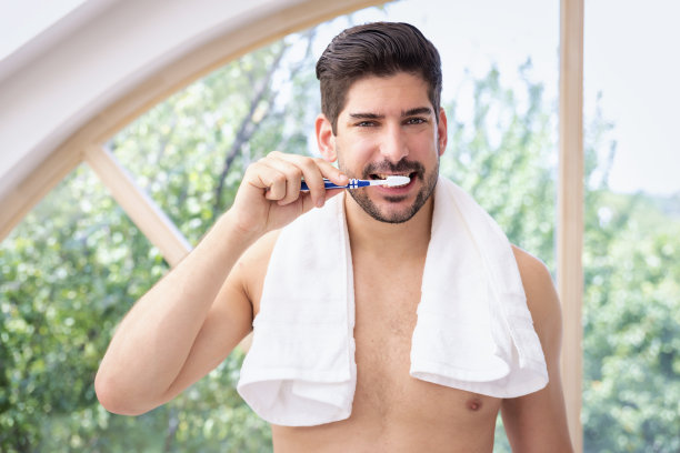 一个满脸胡茬的男人站在家里的浴室里刷牙图片下载