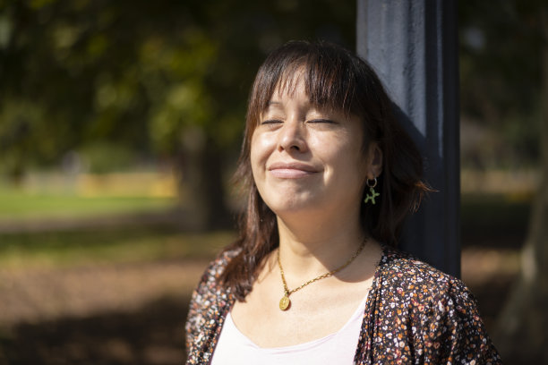 公园里靠在灯柱上的拉丁女人图片下载