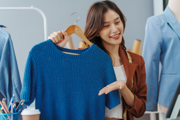 如何在网上开一家服装店经营服装!年轻自信的亚洲女性时尚老板社交媒体网红现场卖衣服，新产品在家办公小生意电商。图片下载