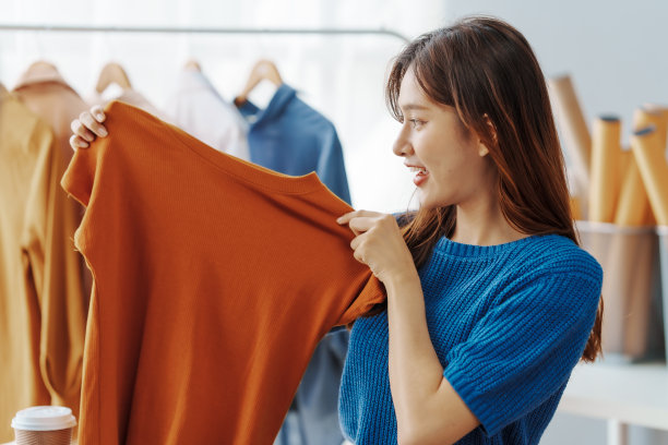 如何在网上开一家服装店经营服装!年轻自信的亚洲女性时尚老板社交媒体网红现场卖衣服，新产品在家办公小生意电商。图片下载