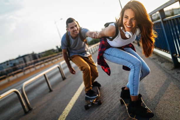 快乐的年轻人在户外玩滑板的照片图片下载