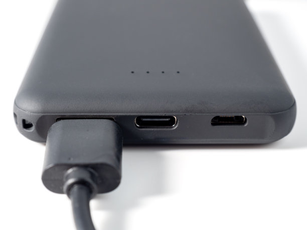 白色背景为移动设备充电的充电宝。带电源的智能手机充电器。图片下载