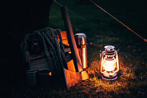 手电筒老式的煤气灯放在草地上，旁边是保温瓶，图片下载