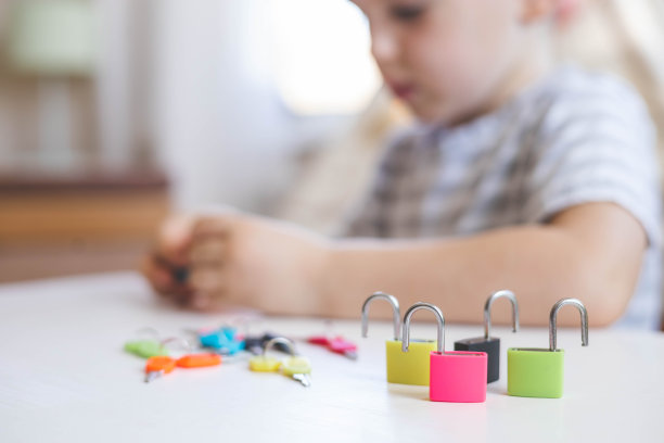 孩子们用蒙台梭利的材料和彩色的锁一起工作。拿起钥匙。发展精细运动技能。图片下载
