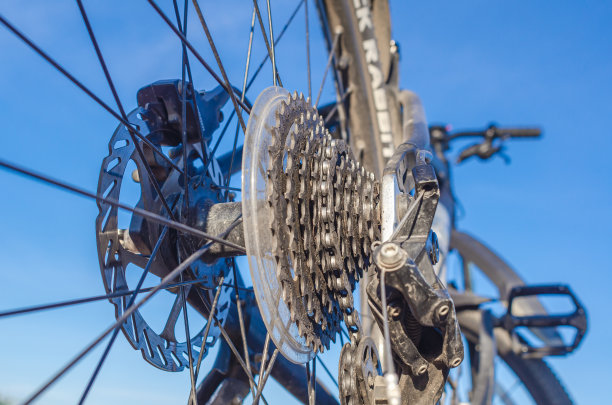 自行车后轮上的齿轮星星，近距离与自然对抗图片下载