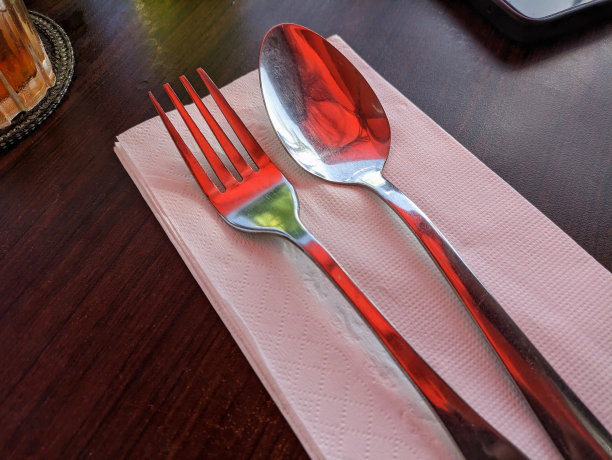 勺子和叉子放在纸巾上图片下载