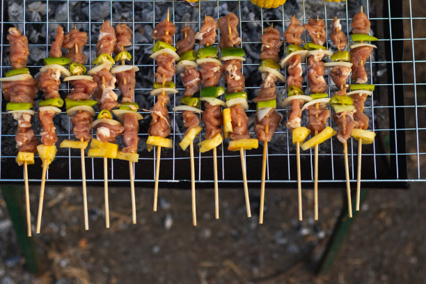 烧烤聚会用的肉和串料放在烤架上烤烧烤，为今晚家人参加烧烤聚会做好准备。派对背景图片有文本的复制空间。图片下载