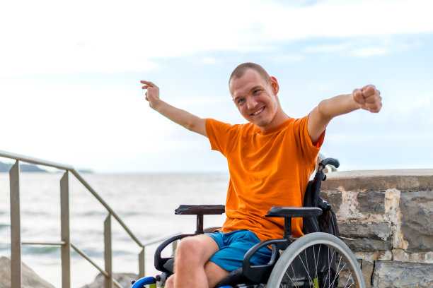 一个非常快乐的残疾人坐在轮椅上度假的画像图片下载
