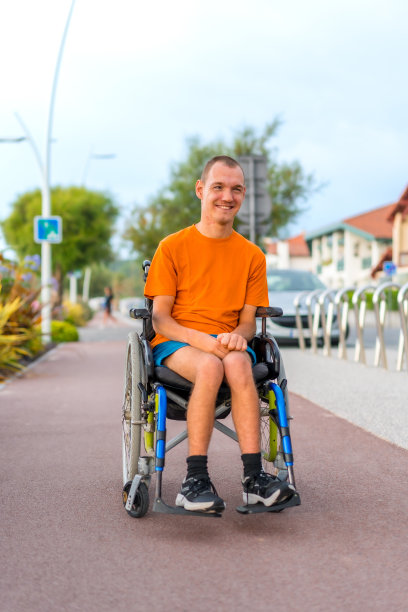 一个非常快乐的残疾人坐在轮椅上在海滩度假的肖像图片下载