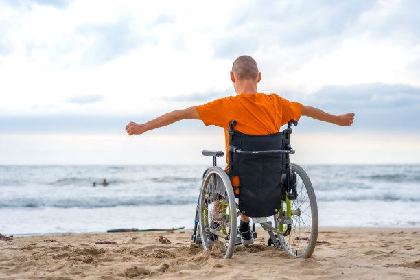 沙滩上一位仰面坐在轮椅上的残疾人图片下载