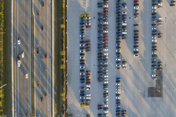 鸟瞰图的经销商停车场与许多全新的汽车出售附近宽的美国高速公路。美国汽车工业发展理念图片下载