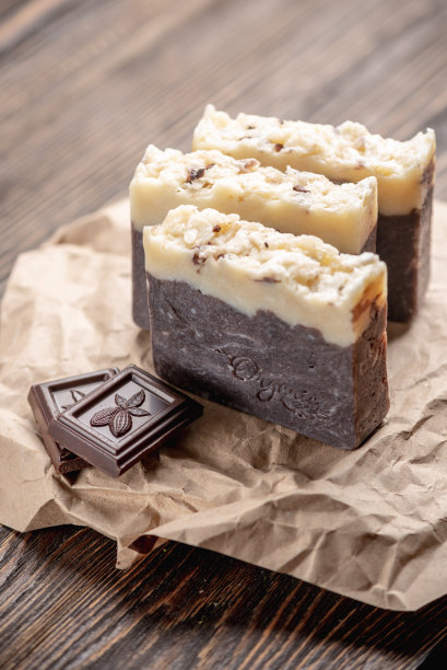 木桌上用牛皮纸包装的天然手工巧克力香皂图片下载