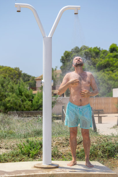 迷人的年轻白人男子在沙滩上沐浴，享受阳光明媚的一天。图片下载