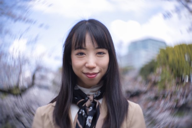 一个日本女人在樱花后面的漩涡肖像特写图片下载