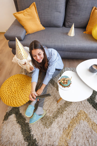 一名女子为狗狗庆祝生日，她和狗狗自拍得很开心图片下载