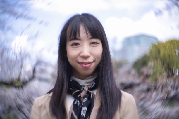 一个日本女人在樱花后面的漩涡肖像特写图片下载