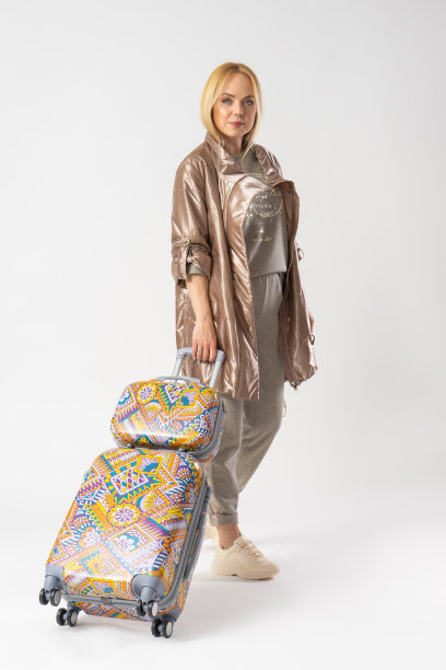 女游客穿着休闲服，带着大旅行箱出门旅游。图片下载