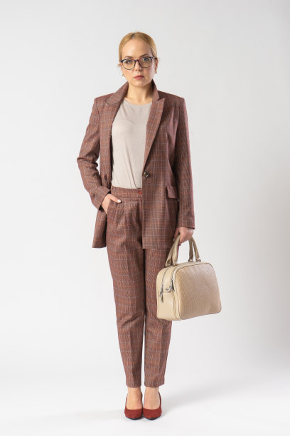 年轻的金发女人戴着眼镜，穿着办公室套装，手里拿着手提包。图片下载