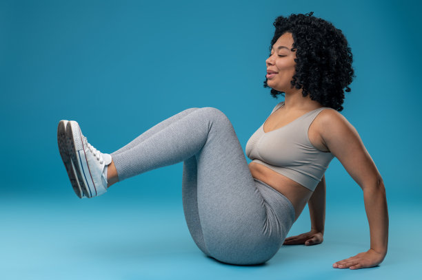 年轻的卷发女人在练腹肌图片下载