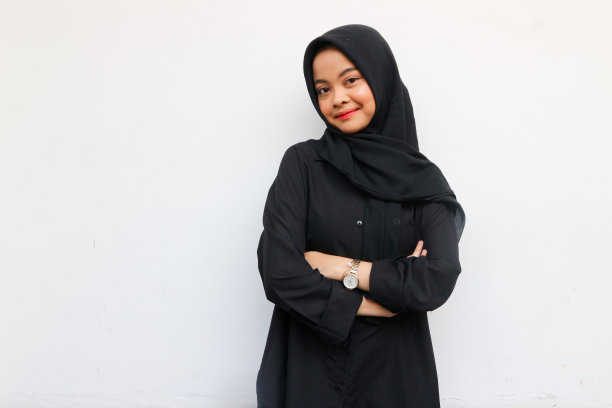 漂亮的年轻亚洲女人穿着黑色衬衫和头巾，微笑着快乐，看起来自信，孤立在白色的背景下图片下载