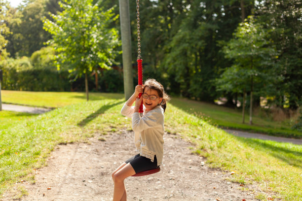 在公园里荡秋千的孩子。孩子们在户外玩耍。图片下载