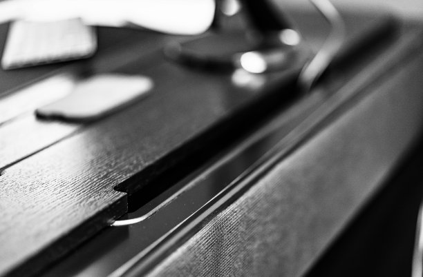 桌上有带无线充电器的手机。现代职场配件图片下载