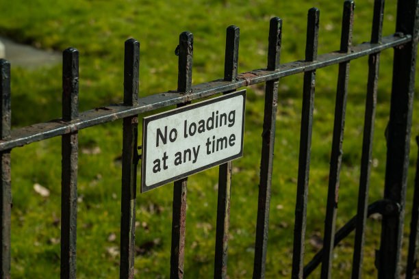 指示或禁止在一天中的任何时间装载货物的白板。金属栅栏上的标志。图片下载