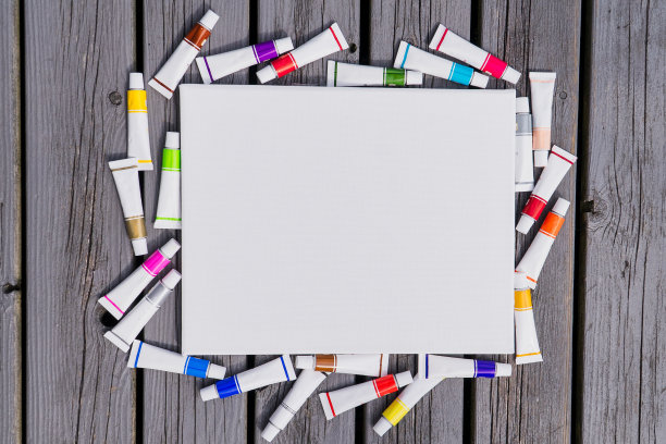 背景空白的白色帆布与管的彩色油漆在木头上图片下载