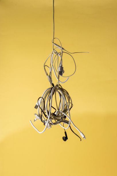 一根电缆和电线挂在一堵黄色的墙前图片下载