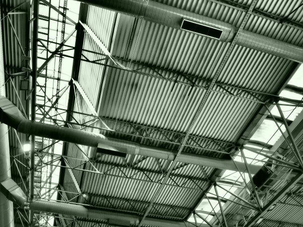 机库、生产车间或体育馆的屋顶金属结构、梁、支撑元件。大厅和房间的通风系统。天窗。工业内部。图片下载