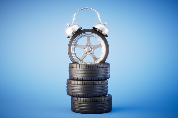 该给汽车换轮胎了。带轮子的轮胎和蓝色背景的闹钟。三维渲染图片下载