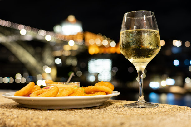 晚上，在波尔图河边的一家餐馆里吃着炸鱿鱼，喝着白波特酒，欣赏着美丽的景色图片下载