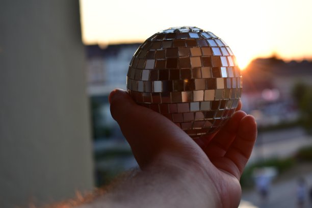 夕阳下手里拿着迪斯科球图片下载